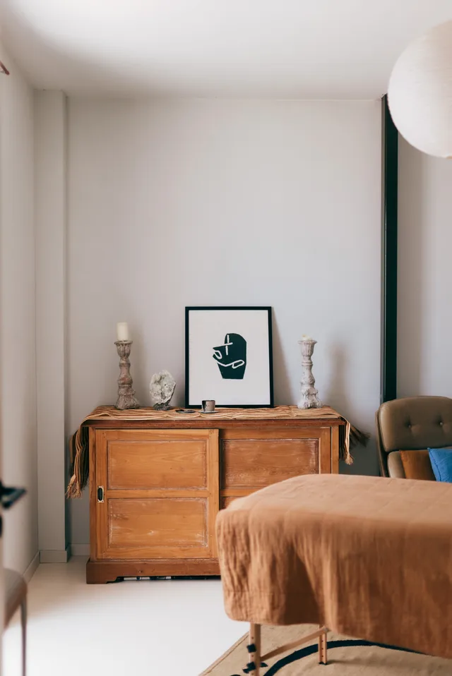 The treatment room: massage table and a wooden cabinet with candles and artwork